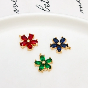 Detailed macro view of zircon flower pendants in red, blue and green on white background
