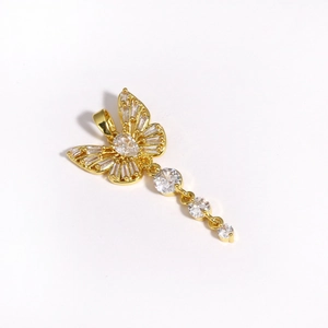 Macro detail of a gold butterfly pendant with sparkling cubic zirconia and tassels