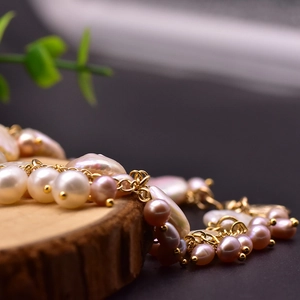 Elegant multi-layer natural baroque pearl bracelet with gold metal chain on wood