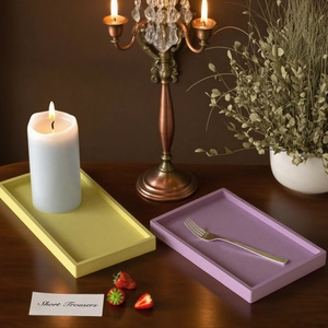 Modern rectangular resin trays in yellow and purple set on a rustic wooden table scene