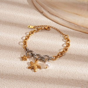 Close-up of ocean-themed bracelet with starfish, star charms, and white pearl detail