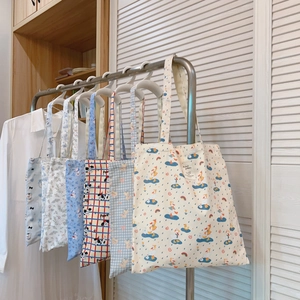 Detailaufnahme von sechs süßen Canvas-Tragetaschen mit blauen und floralen Motiven