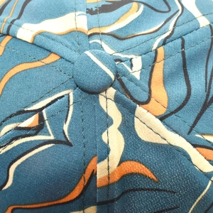 Macro detail of a colorful baseball cap showing top button and stitching quality