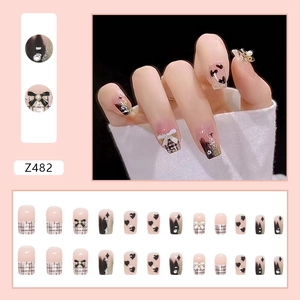 Faux ongles chic rose et noir avec nœuds 3D et perles pour un style élégant