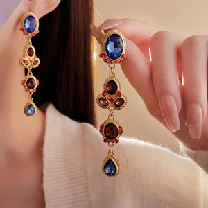 Vintage gold metal drop earrings with colorful crystals and fringe in a royal court style