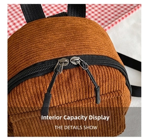 Close-up of brown corduroy backpack showing dual metal zippers and texture detail