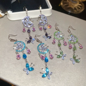 Detail view of colorful tassel earrings with crystal flower charms and butterfly pendants