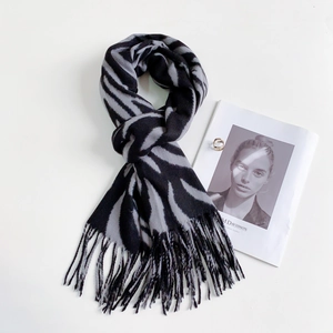 Detail showing soft cashmere striped scarf with black and gray zebra print and tassels