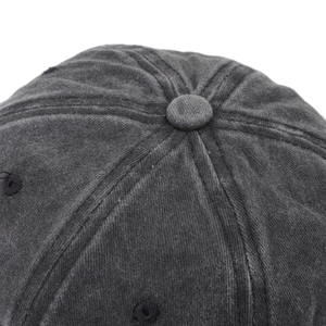 Top detail of dark gray washed cotton baseball cap with ventilation eyelets and stitching