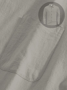 Detail shot of grey linen shirt fabric texture and front pocket stitching finish