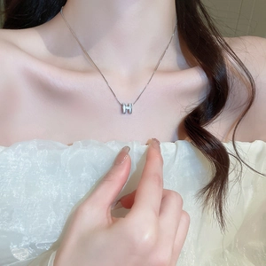 Elegant silver H-letter zircon geometric pendant necklace on model's collarbone