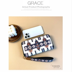 Detail view of ethnic geometric pattern leather wallet with wristlet and zip closure
