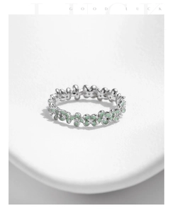 Macro detail of silver flower ring with mint green enamel and tiny sparkling zircon stones