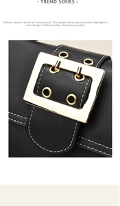 Detail of a vintage black leather bag featuring a large gold buckle and white stitching