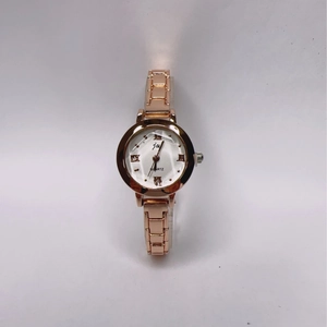 Detail of rose gold quartz watch with white dial and elegant Roman numerals scale