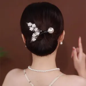 Détail d'une pince à cheveux queue de poisson élégante avec fleurs et perle blanche