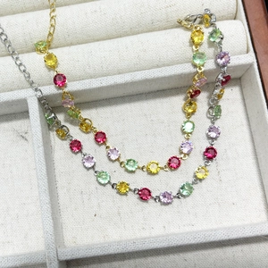 Detail of colorful round zircon bracelets in gold and silver finishes with claw setting