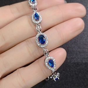 Macro view of blue sapphire and silver bracelet featuring oval and pear cut stones