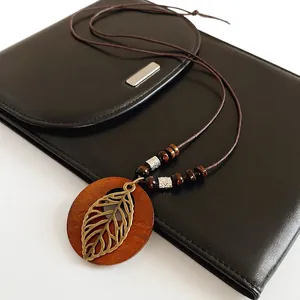 Sautoir ethnique avec pendentif en bois, feuille creuse en bronze et perles marron