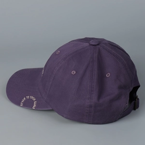 Detail of dark purple baseball cap featuring embroidery and adjustable metal buckle