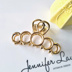 Close-up of golden geometric hollow ring metal hair claw clip for women's hairstyles