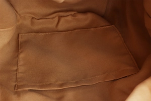 Close-up of woven bag interior featuring a neat fabric lining and open slip pocket