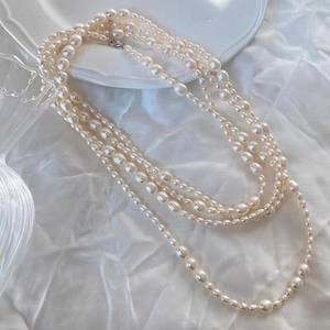 Elegant multi-layer necklace with white baroque freshwater pearls on silk fabric