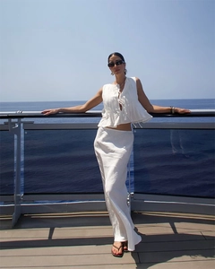 Close-up of white pleated linen two-piece vacation set with sleeveless tie-up crop top