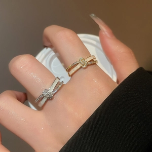 Close-up of 18k gold and silver interlocking rings with zircon pavé and white inlay