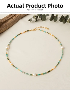 Detail shot of a handmade colorful stone beaded necklace with white pearls on a beige fabric