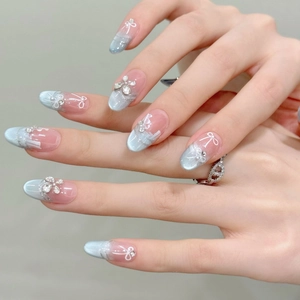 Faux ongles œil de chat bleu glacé avec bords scintillants, nœuds peints et zircons