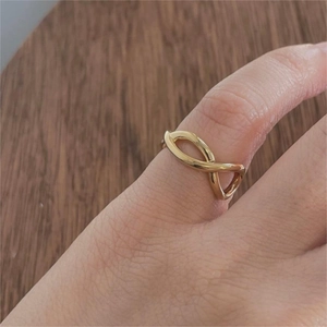 Close-up of minimalist golden infinity ring on hand with polished metallic finish