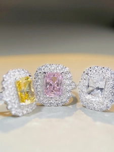 Macro view of Radiant cut rings with pink, yellow and white halo set cubic zirconia