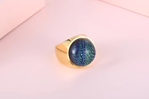 Detail shot of a chunky gold stainless steel ring with a celestial blue stone