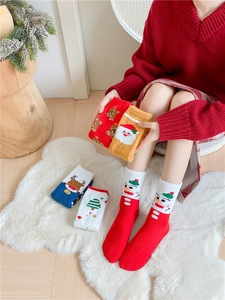 Détail de chaussettes de Noël épaisses en polaire corail avec motifs d'élans et Père Noël
