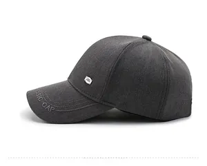 Detail of dark grey baseball cap with classic embroidery and metal logo decoration