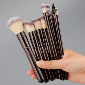 Detailed close-up of a 10-piece makeup brush set with gradient bristles held by hand