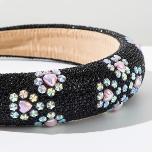 Detail of wide headband featuring pink heart pearls and sparkling crystals on black base