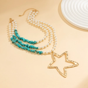 Detail of multi-layer necklace with golden star pendant, pearls and turquoise beads
