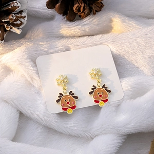 Detailed close-up of Christmas reindeer earrings with snowflake and gold bell charms