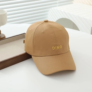 Detail view of khaki cotton baseball cap featuring yellow DINO embroidery and top eyelets