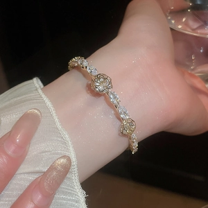 Detail of 14k gold plated flower bracelet with marquise-cut zircon and hollow rose design