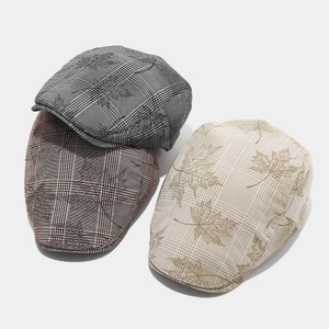 Detailed top view of plaid ivy caps with maple leaf prints in brown, grey, and beige colors