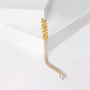 Close-up of golden wheat ear earring featuring sparkling yellow gems and tassel chains