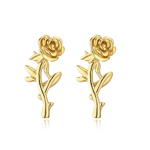 Detalle de pendientes de rosa bañados en oro con hojas y un acabado metálico pulido