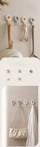 Adhesive wall hooks in cream and gray for kitchen pans and bathroom towels macro view