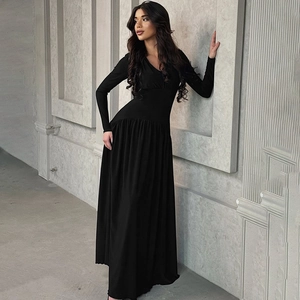 Close-up of elegant black long-sleeve maxi dress with slim waist and V-neckline