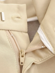 Détail du tissu en coton kaki montrant la fermeture éclair et la qualité des coutures
