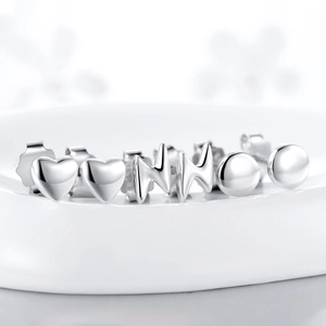 Exquisite S925 sterling silver mini heart and lightning stud earrings set on a white tray