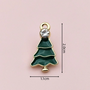 Macro view of green enamel Christmas tree charm with gold trim and crystal stud details